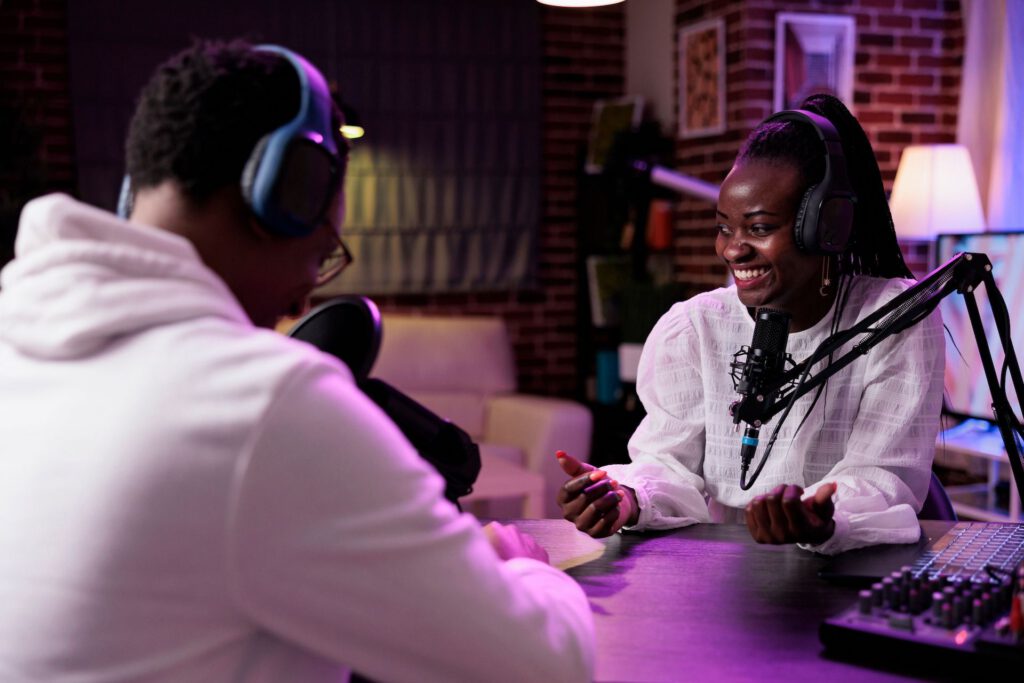 Two podcasters engaging in a lively conversation, surrounded by microphones and audio equipment, symbolizing the creative industries that benefit from tailored financial services.