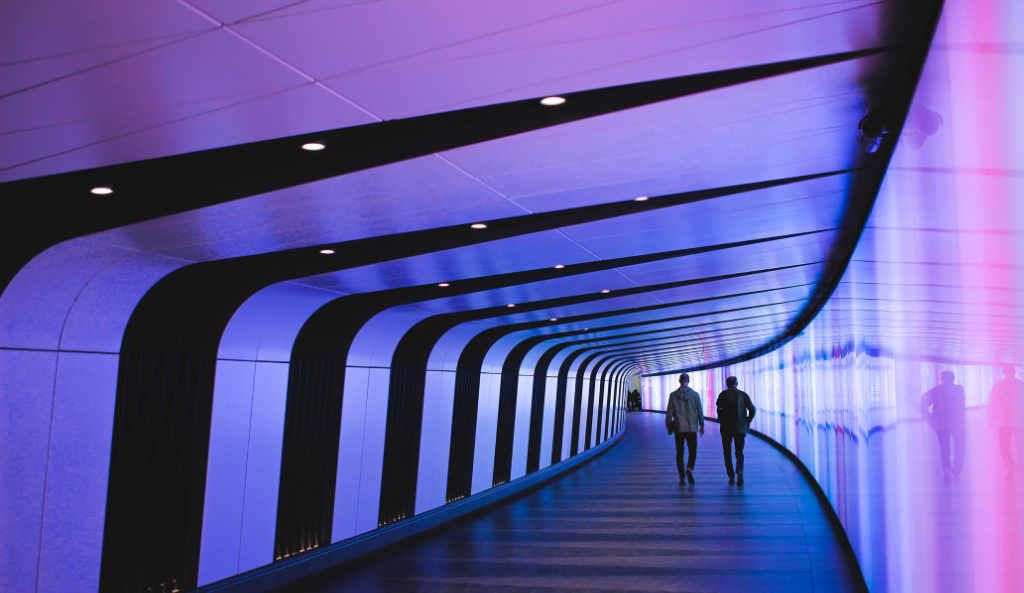 A futuristic, illuminated tunnel with purple and blue lights, representing the innovative paths and creative industries that thrive with expert financial guidance and accounting services.