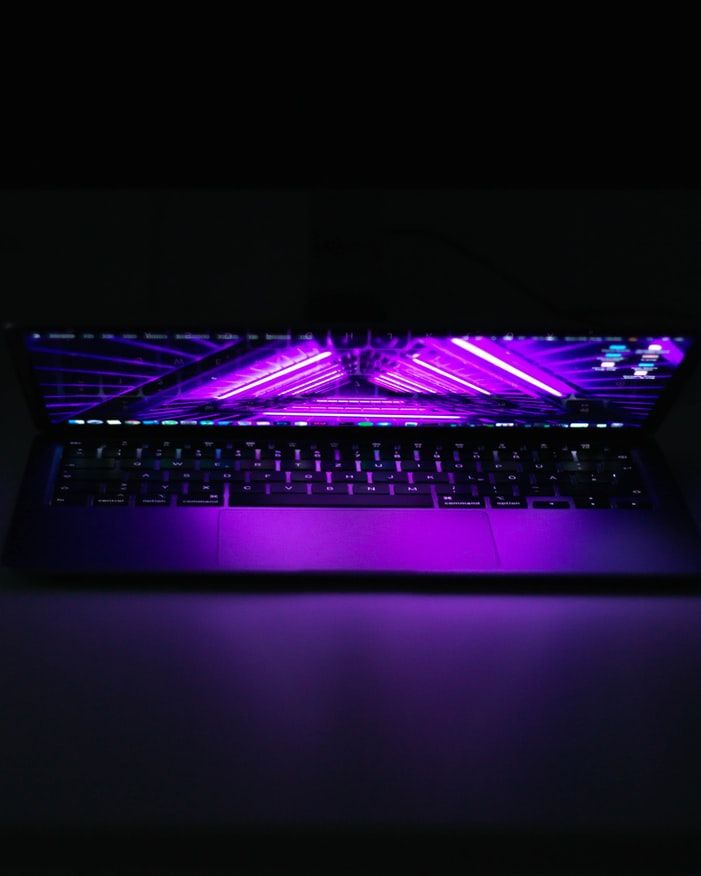 Laptop computer with purple neon lighting effects - accounting services for digital creatives and tech professionals
