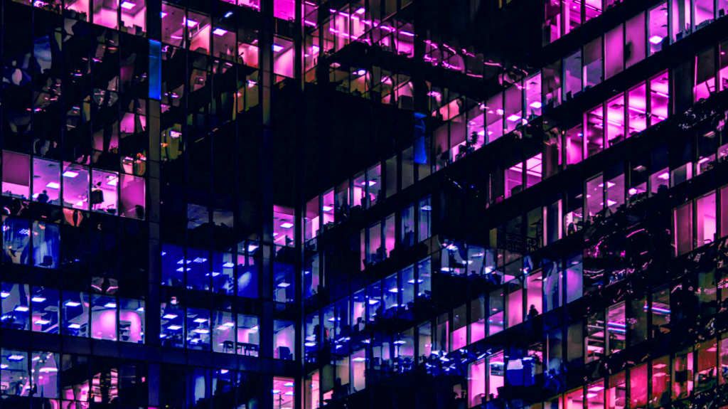 A vibrant cityscape at night with illuminated office windows, symbolizing the dynamic and ever-evolving world of creative businesses that rely on specialized accounting services.