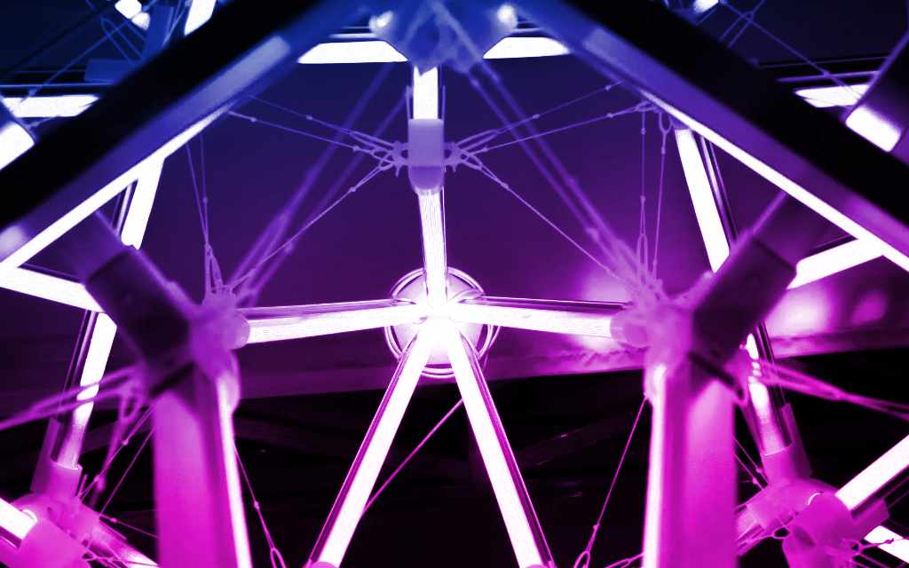 Illuminated ferris wheel structure with purple and pink lighting effects - accounting services for event planners and entertainment industry professionals