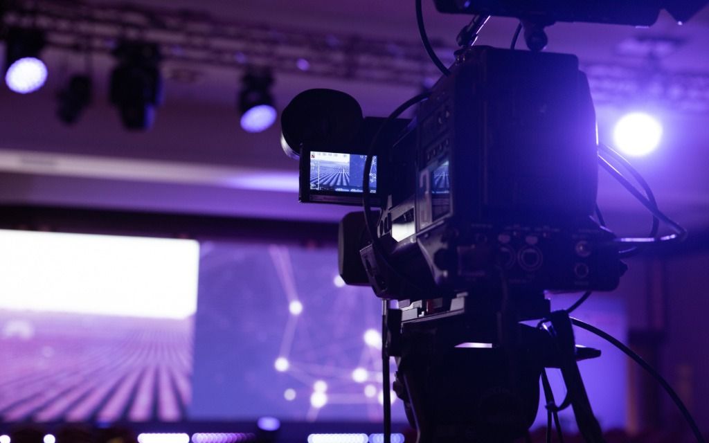 Professional video camera with viewfinder in purple-lit studio with stage lighting - accounting services for filmmakers and video production professionals